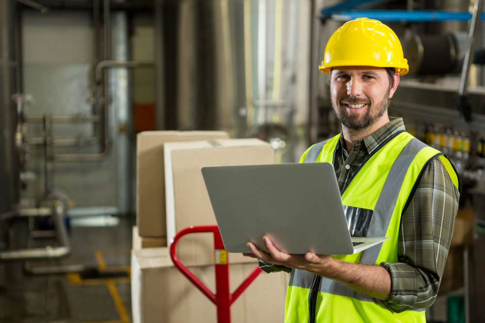 Warehouse operations specialist reviewing orders on a laptop