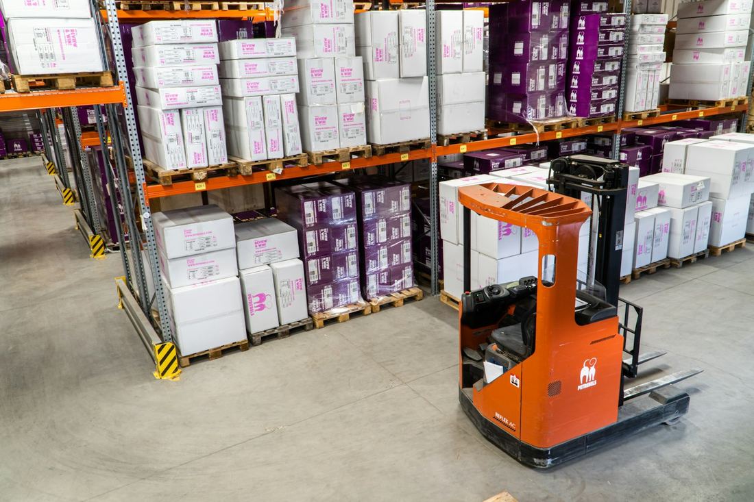 Organized warehouse with racked inventory and a forklift